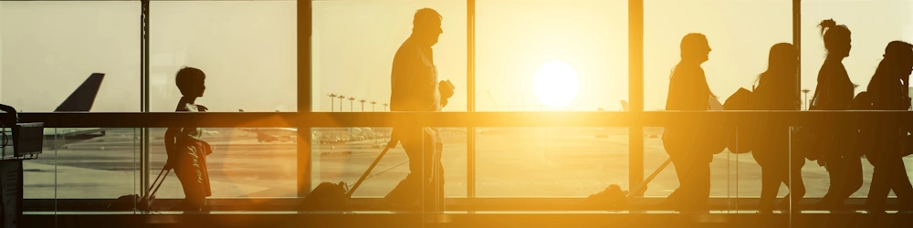 People in motion at airport in sunset